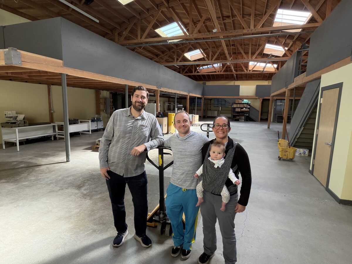 The BioKEA team in the freshly-moved-in Berkeley warehouse — Austin, Sean, and Michelle with baby Cora in a sling